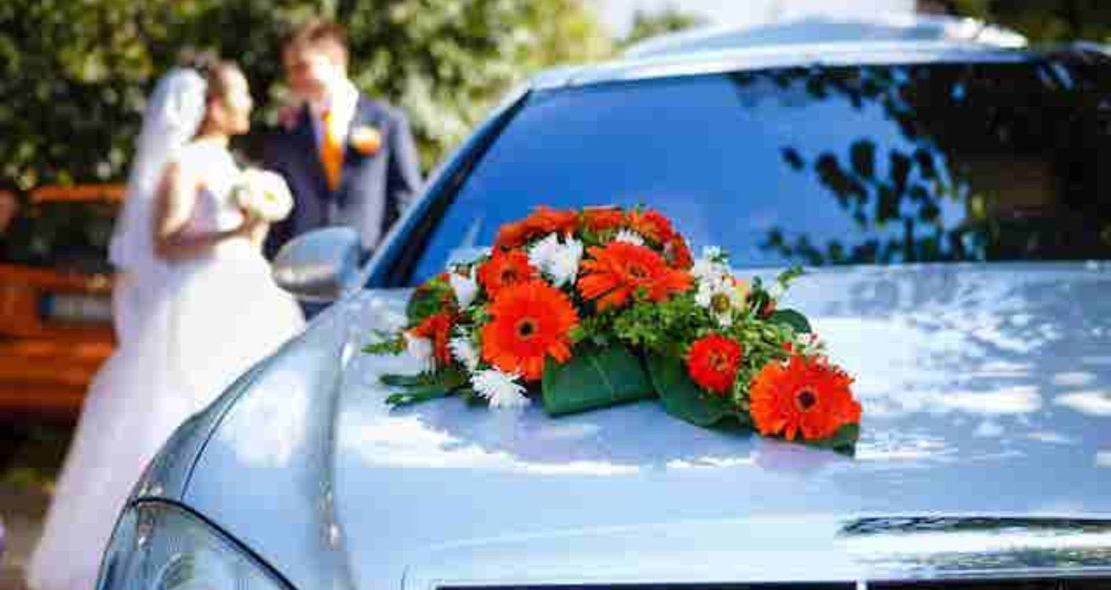 Groom and bride standing near car